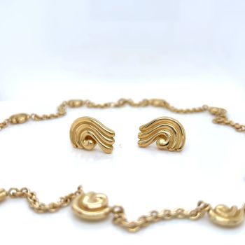 Gold earrings and a necklace on a white background